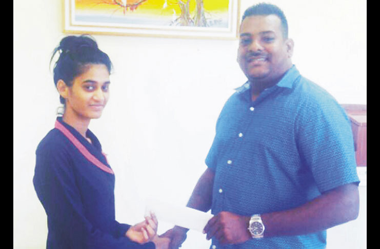 Roy Jafferally, a member of the Guyana Cup organising committee collects the sponsorship cheque from a representative of the Berbice River Bridge Company.