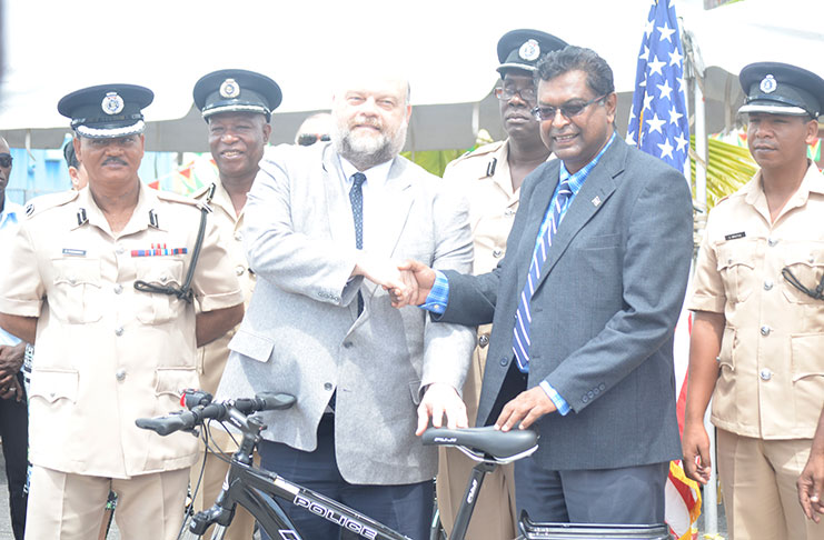 U.S. Ambassador Perry Holloway hands over the bicycles and accessories to Minister of Public Security Khemraj Ramjattan