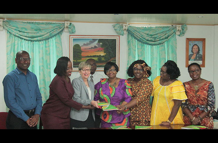 Minister of Public Health, Volda Lawrence, receives a copy of the manual from USAID’s Country Director, Ms. Caroline Healey, in the presence of other officials of the Ministry and USAID.
