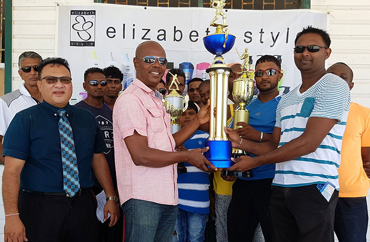 Newly elected Marketing Manager Suresh Boodhoo hands over trophies and cheque to ECCB Competitions Committee chairman Raymond Barton in the presence of ECCB president Bissoondyal Singh and representatives of clubs.