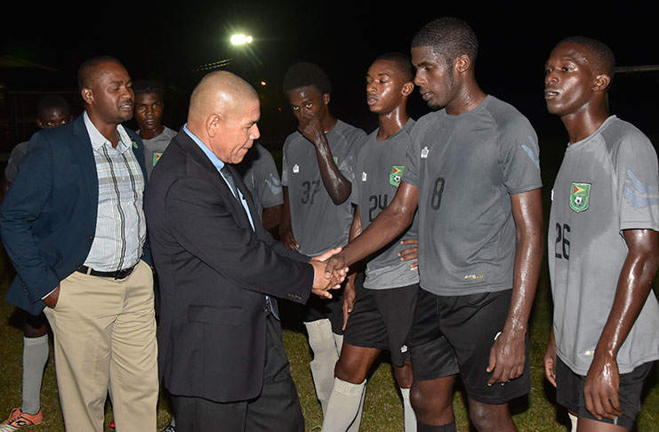 Sport Minister Dr George Norton greets 17-year-old Jeremy Garrett during his impromptu visit to the Golden Jaguars camp on Wednesday. (Adrian Narine photo)