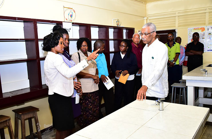 President David Granger having a discussion with teachers of the Science Department during a tour of the science laboratory (Ministry of the Presidency photo)