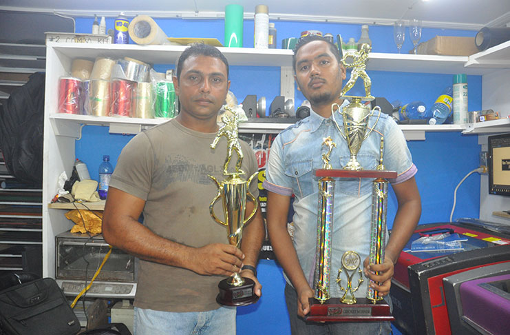 Zaheer Mohamed (left) and Stephen Persaud of Trophy Stall display the trophies.