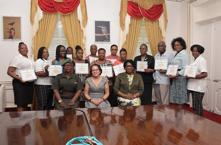 L-R seated: Guyana Defence Force Warrant Officer, Weslyn Boodie-Blades, First Lady, Mrs. Sandra Granger and Lieutenant Colonel (Ret’d), Yvonne Smith, of the Office of the First Lady at the closing ceremony for the Grade Two Chef’s Course training. The participants are pictured standing