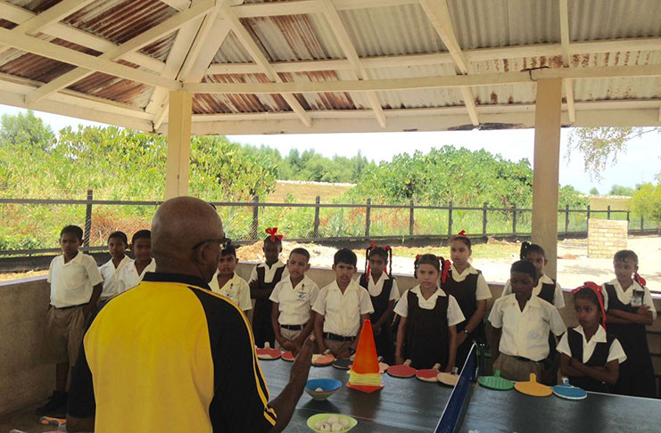 National Coach, Linden Johnson, imparting his knowledge to the attentive students and teachers.