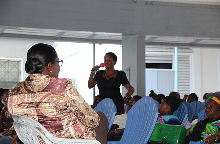 Minister of Education Nicolette Henry (seated) listening to the views of the sweepers/cleaners
