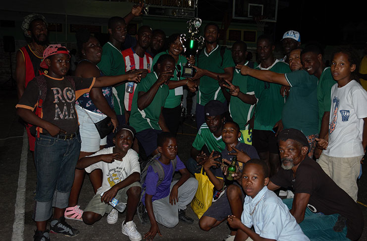 Chairperson of the Organising Committee for the PNCR 60th Anniversary Day of Sports, Minister Annette Ferguson (centre), hands over the winning trophy to Swag Entertainment captain, Shane Luckie, in the presence of teammates on Sunday