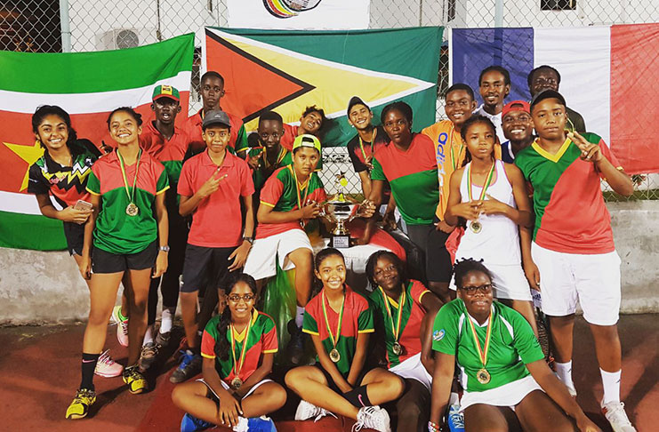A jubilant Guyana team celebrate with their trophy and medals