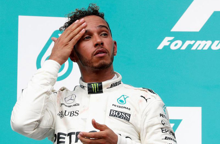 Mercedes’ Lewis Hamilton wipes his forehead on the podium. REUTERS/Edgar Su