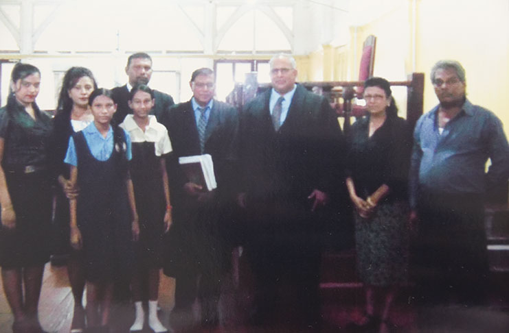 New Attorney-at-Law Ravindra Mohabir, third left in back row. Fourth and third right, respectively, are Senior Counsel Vidyanand Persaud who presented the petition, and Justice Sandil Kissoon before whom the petition was presented. 
Others in the photo are, from left: Sister, Kristy; wife Sharmila; daughters, Elizabeth and Raveena, and his parents (Photo by Adrian Narine)