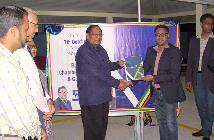 Prime Minister Moses Nagamootoo receives his copy of the Potential 5 from Region Five Chamber of Commerce President Imran Saccoor at the launch at Rosignol, West Bank Berbice, last weekend. Looking on are Regional Chairman Vickchand Ramphal and Minister of Business Dominic Gaskin