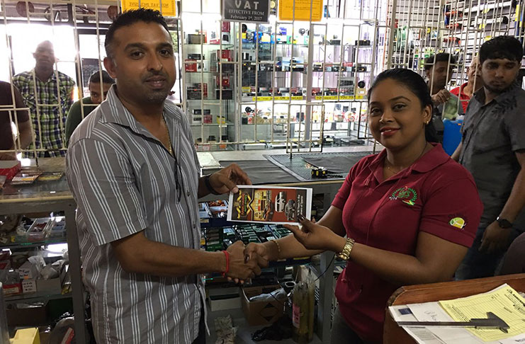 Yogeshwar Ragbeer hands over his company’s sponsorship along with some flyers for the GMR&SC International Race of Champions.