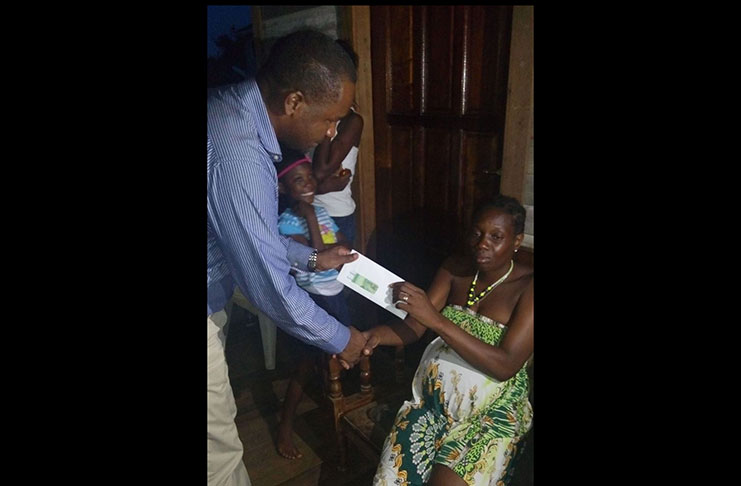 GFF president Wayne Forde makes a monetary contribution to the mother of Glensean Skeete.