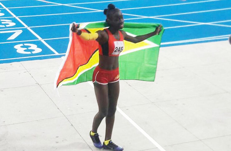 Deshanna Skeete proudly celebrates her 400M win at the South American Youth Games with the Golden Arrow Head draped around her.