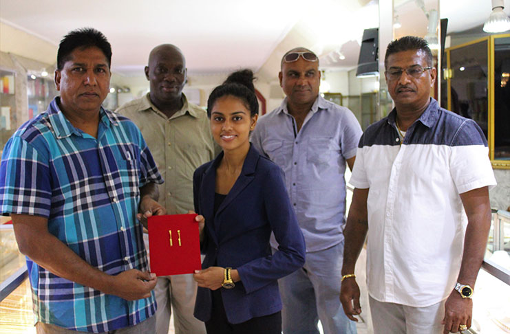 A Steve's Jewellery staff presents the pendants to Surendra Nauth in the presence of other GFSCA officials and Steve Naraine (right)