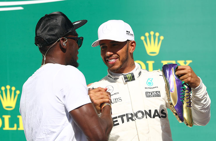 Mercedes driver Lewis Hamilton, of Britain, holds his  running shoes that was presented to him by legendary Jamaican sprinter Usain Bolt  after the Brit won the Formula One U.S. Grand Prix auto race at the Circuit of the Americas, last Sunday in Austin, Texas.