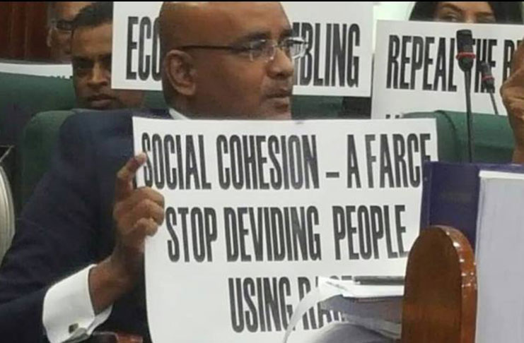 Former President and Opposition Leader Bharrat Jagdeo holds a placard while protesting during President David Granger’s address to the 71st sitting of the National Assembly last Thursday. The placard has the word “dividing” spelt incorrectly as “deviding” (Taken from Facebook)