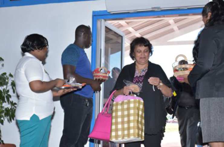 Passengers being greeted by staff of GTA and receiving their Guyanese tokens