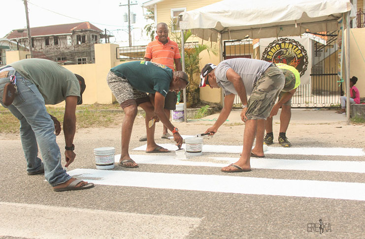 Members of the Sonic Hunters Motorcycle club painting the pedestrian crossing at Queen Street, Wortmanville, between Durban and Norton Street