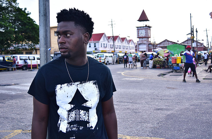 Jamall Hinds wearing one of his Big Market Tees with Stabroek Market in the background (All photos courtesy of Jamall Hinds)