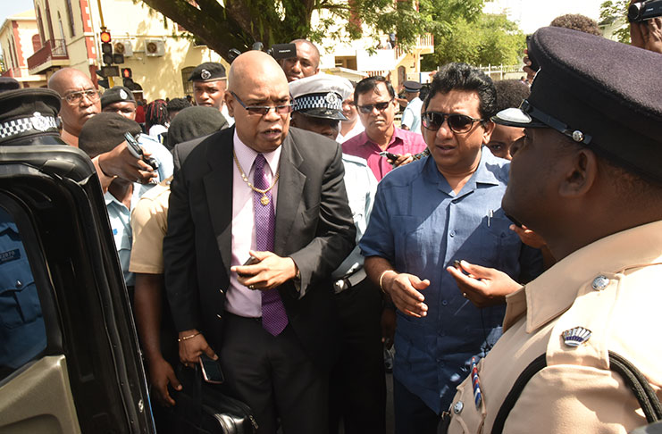 Member of Parliament Juan Edghill being asked to enter  the police vehicle by third in command of ‘A’ Division, Phillip Azore (photo by Adrian Narine)