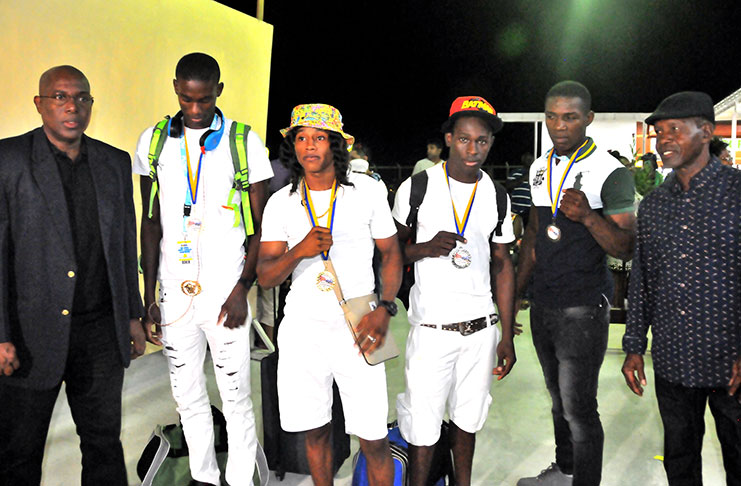 WELL DONE! GBA president Steve Ninvalle (first from left) and Michael Parris (first from right), and the Guyanese fighters at the Cheddi Jagan International Airport upon their arrival from St Lucia. (Adrian Narine photo)