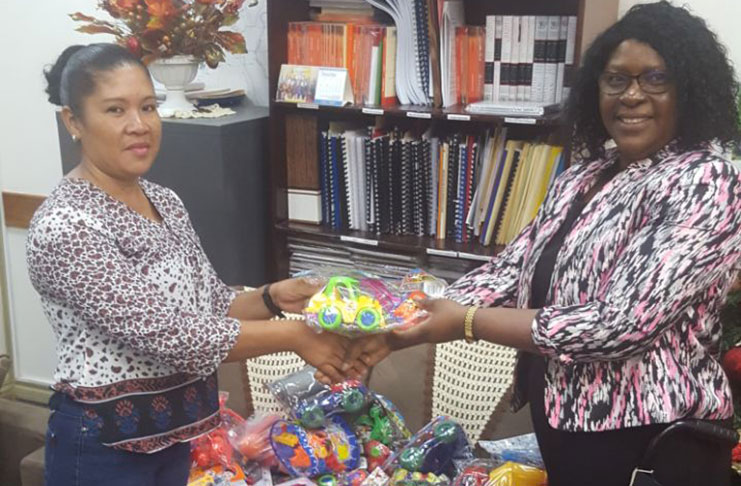 Minister Karen Cummings handing over the toys to  Region One Acting REO Reneta Williams