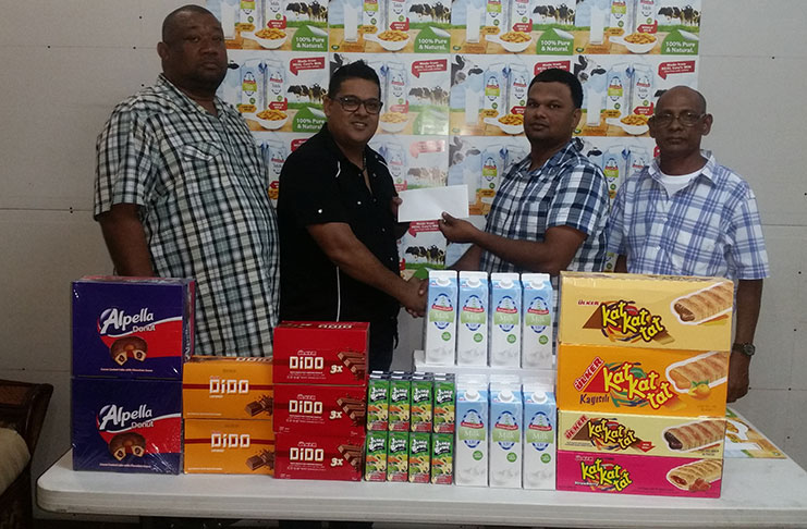 Sueria Manufacturing CEO Frank Sukhu hands over donation to Mark Papannah while Ravin Kissoonlall and Hilbert Foster of the RHTYSC look on.