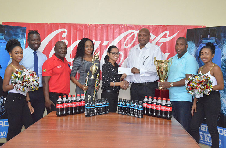 Shenisa Fredericks (Banks DIH official) presents the sponsorship cheque to Nigel Hinds (GABF president) while Mortimer Stewart (Outdoor Events Manager), Troy Peters (Communications Manager), Junior Hercules and Shevon Henry (GABF coordinators) and two cheerleaders share the photo opportunity.