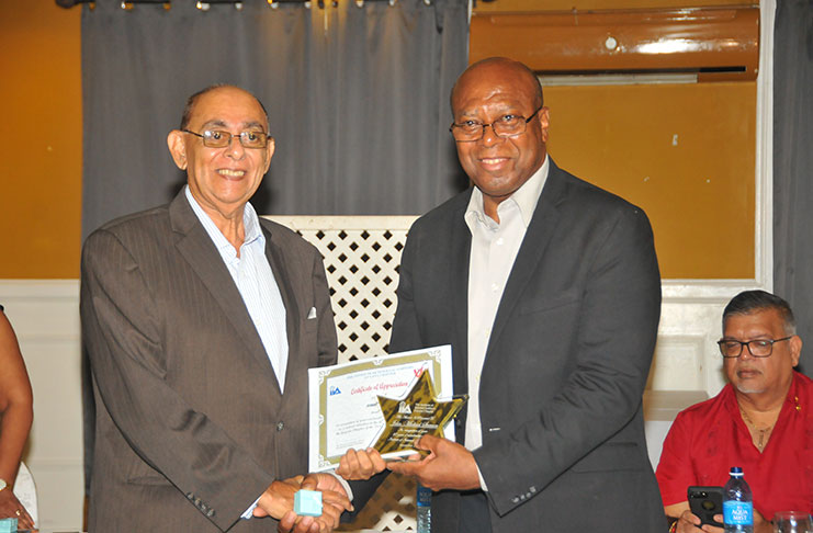 Chair of the IIA Guyana Chapter Board, John Seeram, accepts his award for years of service from Finance Secretary, Ministry of Finance, Dr Hector Butts (Photo by Adrian Narine)