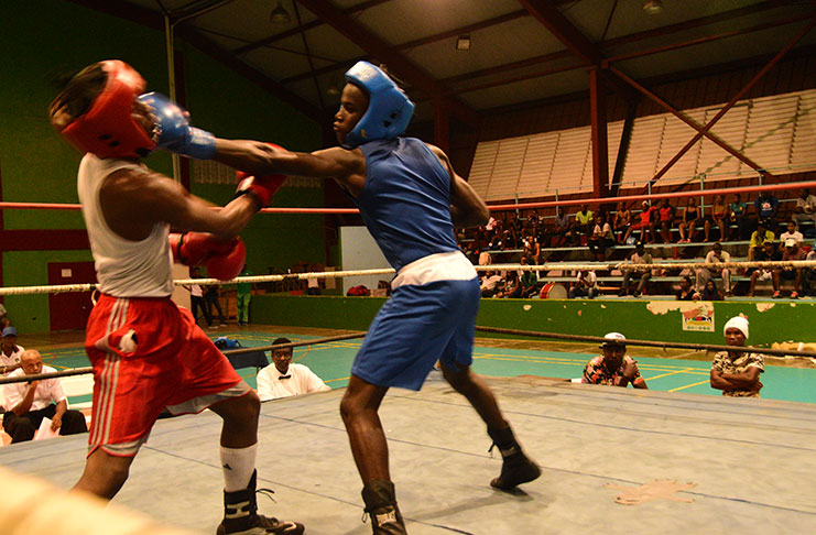 Vergenoegen Boxing Gym’s Christopher Moore (right) connects with a left hand to Omar Pollard in their Youth Lightweight contest of the GBA Terrence Ali National Open championships on Wednesday evening. (Photo by Adrian Narine)