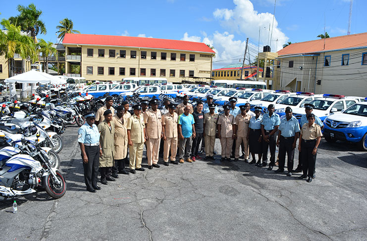 Assistant Commissioner of Police, Mr Clifton Hicken and Mr Hou Jian (seventh and eighth right, respectively) with logistics officers from “A” to “G” Divisions, during the commencement of training on some of the vehicles in the background (Photo by Rabindra Rooplall)