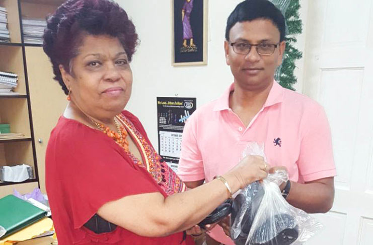 Minister of Social Protection, Amna Ally, receives the donation from businessman, Bonny Singh