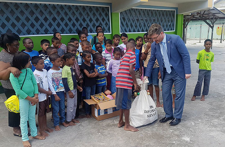 British High Commissioner, Greg Quinn, hands over some of the items to children of  Joshua House