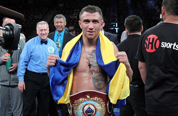 New champion: Vasyl Lomachenko poses with his belt after winning the vacant WBO featherweight title