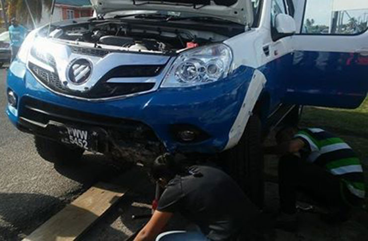 Mechanics changing the wheel of Police Force vehicle PWW 5452