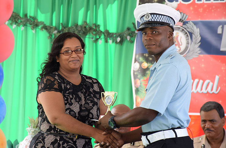 Sergeant Gavin Boyce received awards in four categories, copping the overall Best Cop Award. In this Department of Public
Information photo he receives his trophy from a Laparkan representative, Ms. A. Singh
