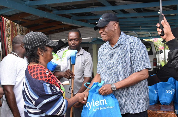 Minister of State, Mr. Joseph Harmon presents a sanitation hamper to a resident of Canal Number One Polder, West Bank
Demerara who has been affected by flooding due to above-normal seasonal rains. A total of 200 hampers were distributed
(Ministry of the Presidency photo)