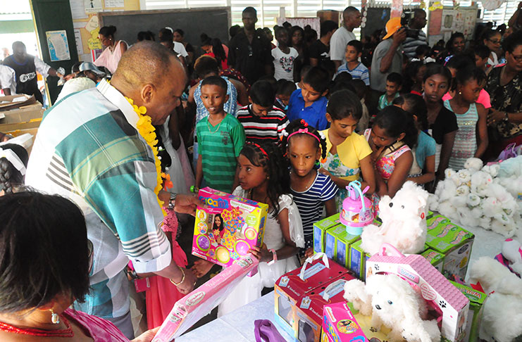 Minister of State, Joseph Harmon distributing toys to children of Leguan during the launch of the Ministry of Social Protection countrywide
Christmas Cheer Programme (Photos by Delano Williams)