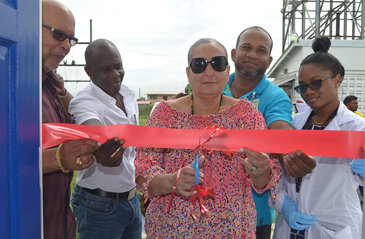 City Mayor, Ms Patricia Chase-Green (centre) is assisted by GWI’s Dr.Van-West Charles (far left), Director of Operations Dwayne Shako, Regional Manager Jawaharlall Ramjug, and Quality Analyst Amelena Squieres (far right)  to cut the ceremonial ribbon to officially open the laboratory