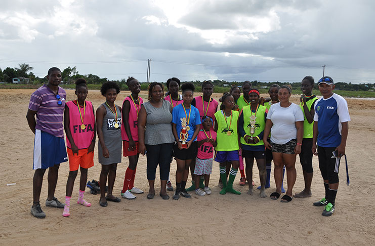 The respective Green and Pink Queens display their medals and trophies following the presentation ceremony in the presence of coaches Devnon Winter (right) and Owan Wills.