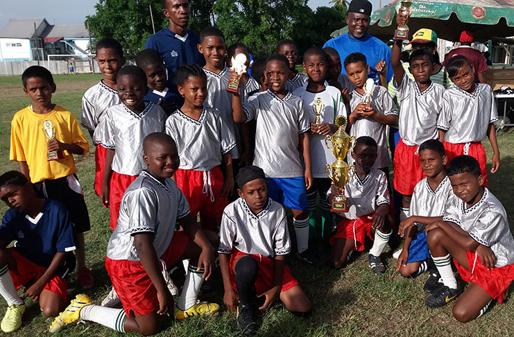 The victorious Corriverton Links Under-11 team pose with their hardware.