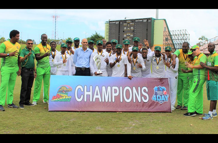 Secretary of the Guyana Cricket Board (GCB) Anand Sanasie and Cricket West Indies Director of Cricket, Jimmy Adams share a moment with the victorious Guyana Jaguars team displaying yhe Headley/Weekes trophy , team management and support staff.