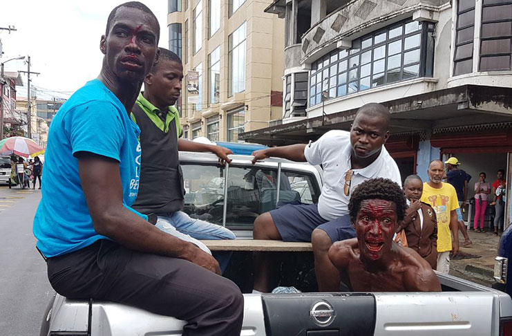 The city constable who was injured (in blue) and the vendor in the pickup flanked by other ranks after the confrontation on Robb Street (Mondale Smith photo)