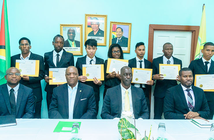 The newly sworn-in land surveyors standing in the presence of Minister Joseph Harmon and officials of the Guyana Lands and Surveys Commission. Seated from L-R are: Magistrate Dylon Best; Minister Joseph Harmon; GLSC CEO and Commissioner, Trevor Benn, and GLSC Secretariat Manager, Durwin Humphrey (Photo by Delano Williams)