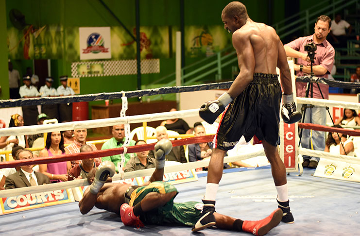 Shawn Corbin is down and out after being tagged by Trinidad’s Sheldon Lawrence with a powerful right upper-cut in the 11th round of their light heavyweight WBC FECABOX title fight (Adrian Narine photos).