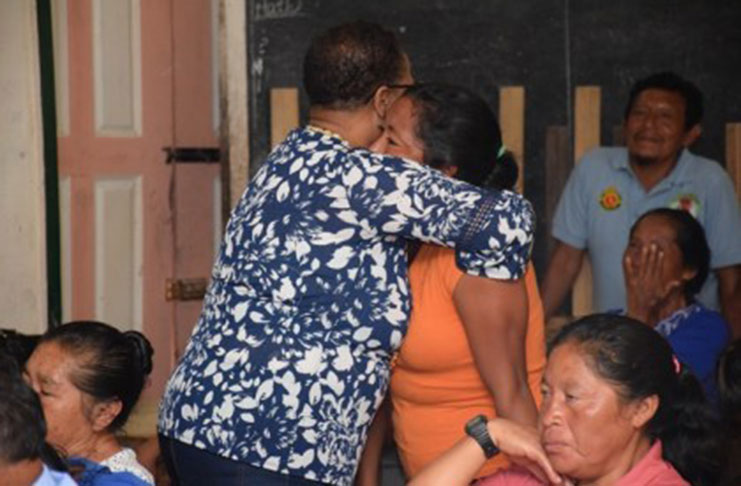 Minister of Public Health Volda Lawrence embraces a young mother of Paramakatoi, who made a passionate plea for better transportation especially for persons who need emergency care