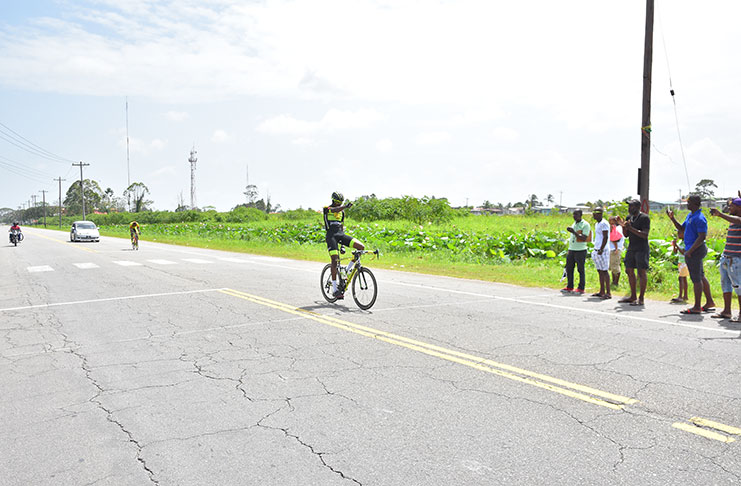 HOME ALONE: Berbice’s Romelo Crawford cruises past the finish line all alone to win the GCF’s 65-mile points’ race yesterday