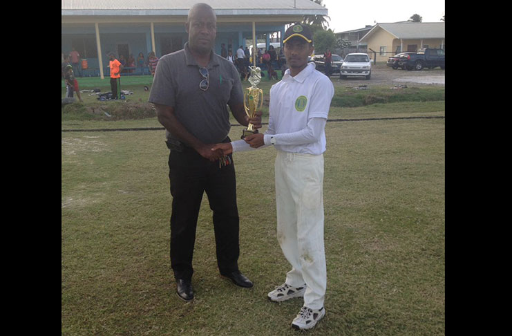 Badesh Parsotam receives the Man-of-the-Match award from match referee, Arleigh Rutherford.