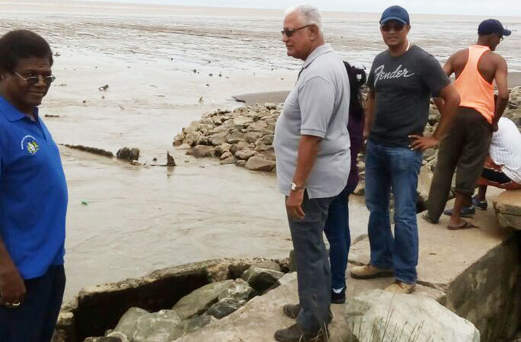 Agriculture Minister Noel Holder with NDIA officials on the section of the seawall were overtopping occurred on Friday